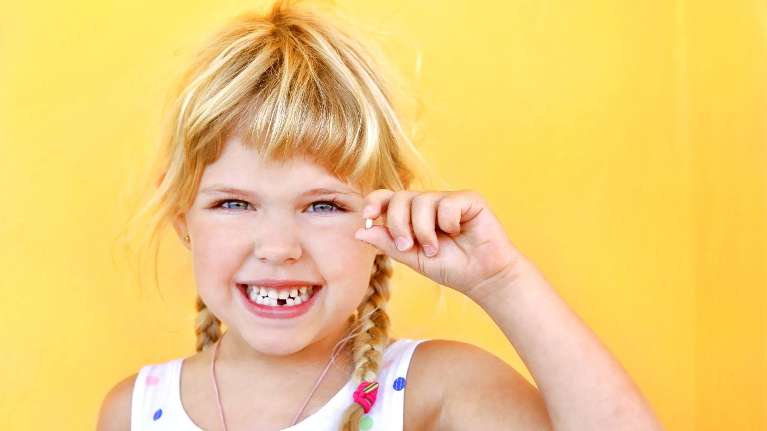 girl with a missing teeth smiling